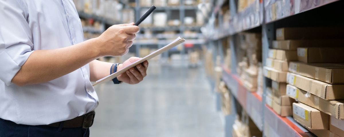 Man with Phone and File in Warehouse | Stock Solutions