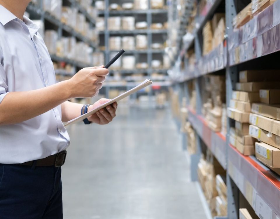 Man with Phone and File in Warehouse | Stock Solutions